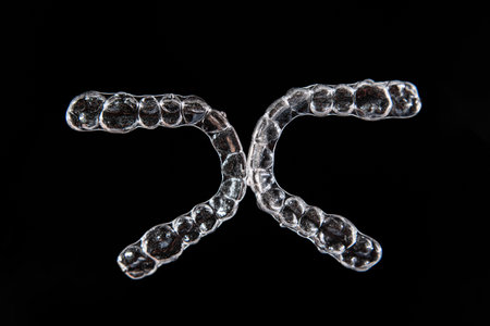 Invisible aligner teeth retainers on a black background
