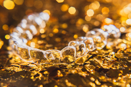 Invisible aligner teeth retainers on a gold backgroundの写真素材