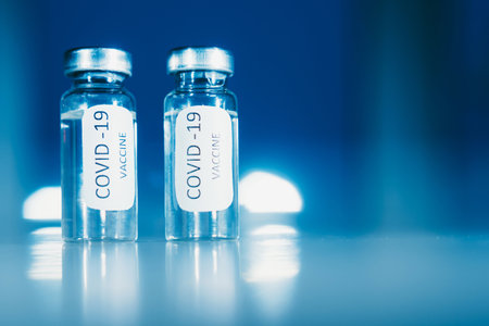 Vaccination against coronavirus COVID - 19. Vial on a blue background close-up. Concept.の写真素材