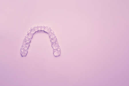Invisible aligner teeth retainers on a pink backgroundの写真素材