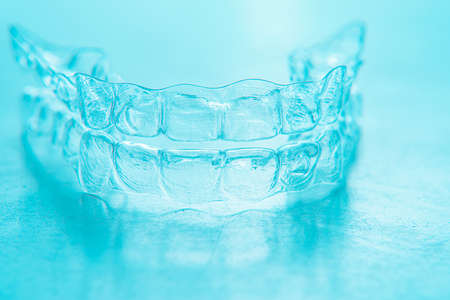 Invisible aligner teeth retainers on a turquoise backgroundの写真素材