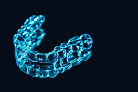 Invisible aligner teeth retainers lie on the mirror in orthodontic officeの写真素材