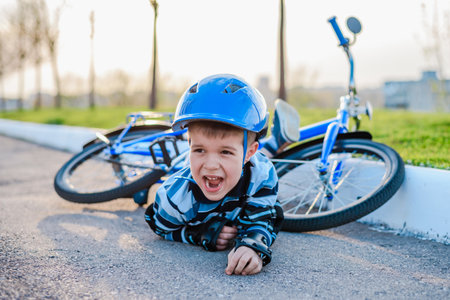 A small child fell from a bicycle crying and screaming in pain.の写真素材