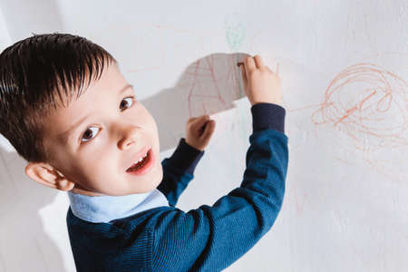 Beautiful child draws on the wall with colored pencilsの写真素材