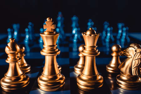 Chess pieces of gold color stand on the board close-up. Board gameの写真素材