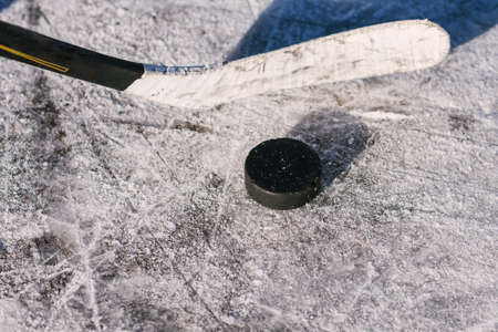 close-up stick and puck on the ice background