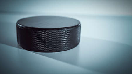 The hockey puck lies on a blue background. Close-upの写真素材