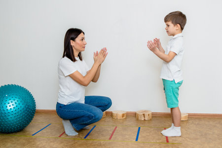 Attractive woman speech therapist teaches boy to pronounce sounds and words correctly in classの写真素材