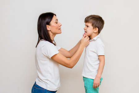 Attractive woman speech therapist teaches boy to pronounce sounds and words correctly in classの写真素材
