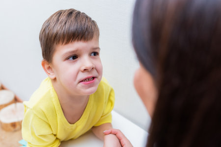 Woman speech therapist helps a child correct the violation of his speech in her officeの写真素材