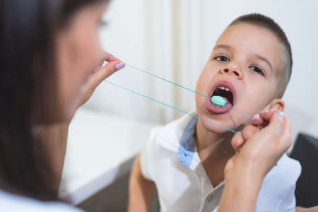 A beautiful woman speech therapist deals with the boy and teaches him the correct pronunciation and competent speech.の写真素材
