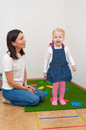 Woman speech therapist helps little girl to correct her speech in her officeの写真素材