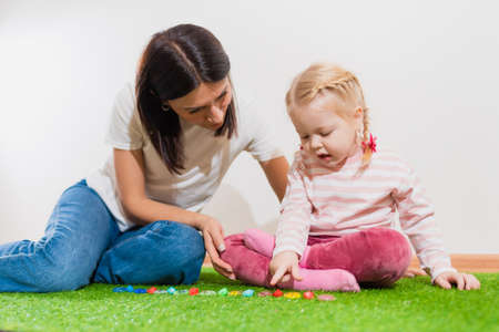 A woman speech therapist teaches a girl the correct pronunciation and competent speech in her officeの写真素材