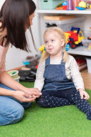 A woman speech therapist teaches a girl the correct pronunciation and competent speech in her officeの写真素材