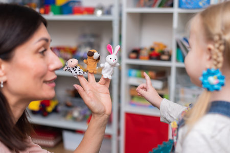 A woman speech therapist teaches a girl the correct pronunciation and competent speech in her office