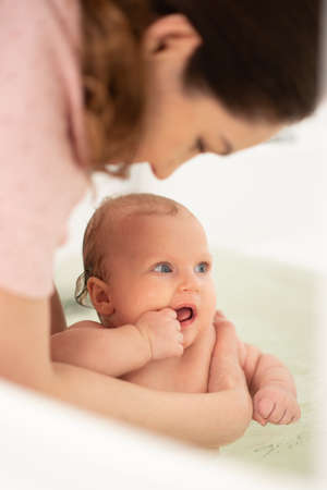 Mom bathes her daughter in the bathroom