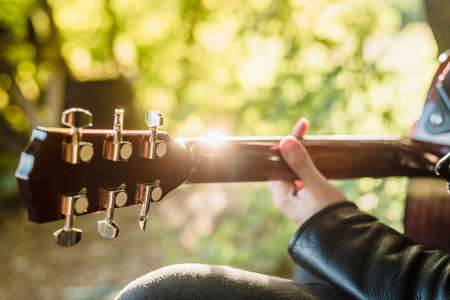 Man playing guitar in nature on a sunny day