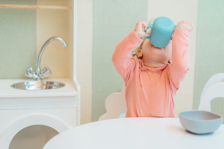 Baby drinking water from a plastic cupの写真素材