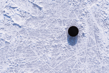 hockey puck lies on the snow macroの写真素材