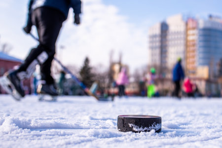 black hockey puck lies on ice at stadium