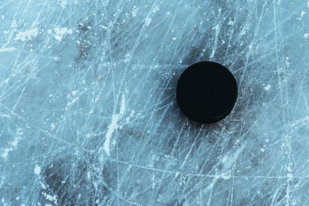 hockey puck lies on the snow macroの写真素材
