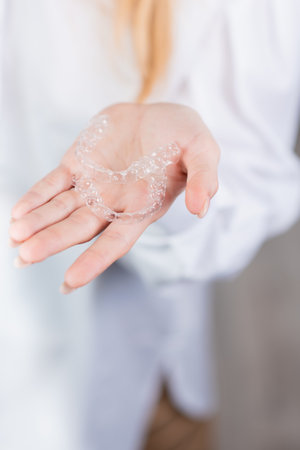 dental care. The doctor of the orthodontist has aligners for teeth in his palm