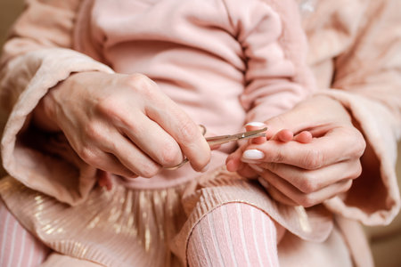 mother cutting nails to baby at homeの写真素材