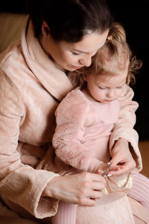 Caring mother cuts her little daughter's nailsの写真素材
