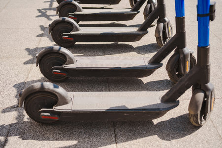 Electric scooters are parked in the city center. public mobile transport stand outside