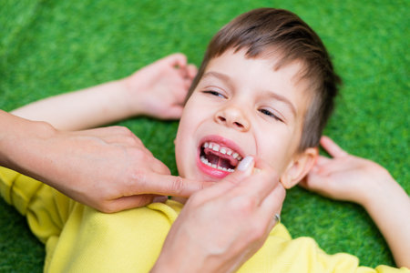 Woman speech therapist helps a boy correct the violation of his speech