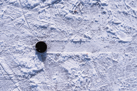 hockey puck lies on the snow macroの写真素材