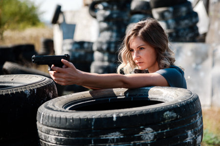 A woman with a pistol in her hand learns to shoot at the shooting range