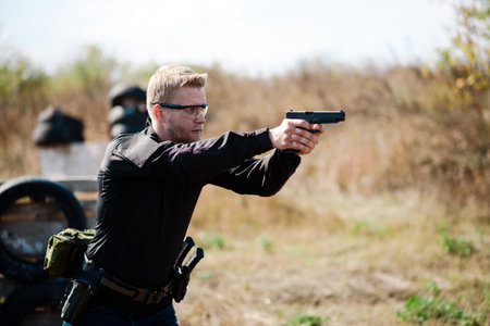 A man with a pistol in his hand undergoes training and learns to shoot.