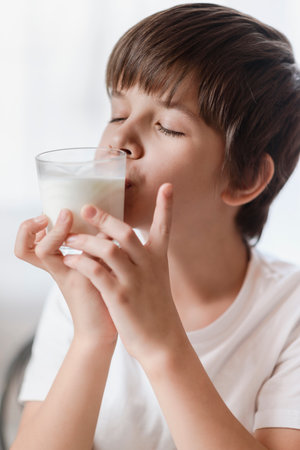Cute boy loves to drink milk at homeの写真素材