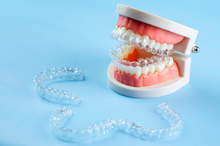 Invisible and removable aligners for teeth alignment on a blue backgroundの写真素材