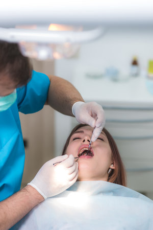 the doctor examines the oral cavity of the patientの写真素材