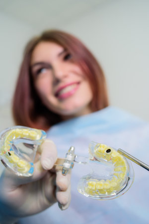 the orthodontist shows the carious cavity in the patient's chewing toothの写真素材