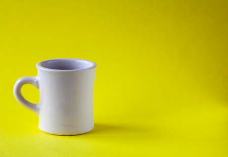 Cup of coffee on yellow backgroundの写真素材