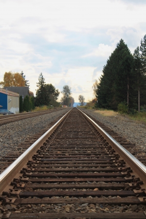 Railroad tracks heading out of a rural small townの写真素材