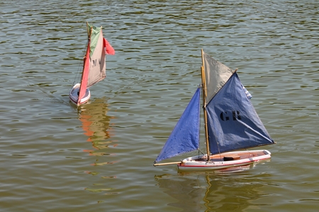 Toy sailboats floating on a pond in a Paris parkのeditorial素材