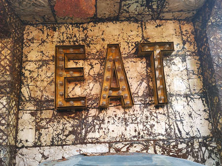Vintage abandoned 'EAT' sign outside a deserted restaurant with distressed panels behindの写真素材