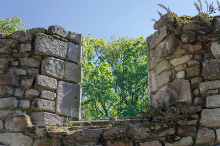 A partially collapsed window in an old stone monasteryの写真素材