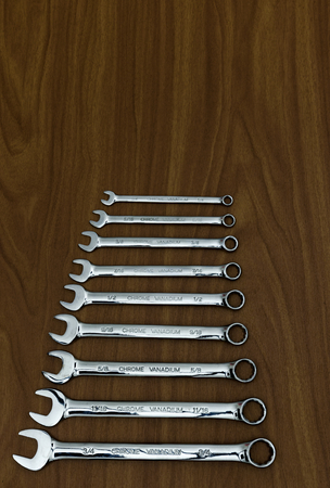 A set of chrome vanadium open ended and ring spanners on a wooden worktop. の写真素材