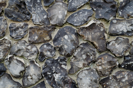 A detailed view of a wall constructed from flint, suitable for use as a background or texture.の写真素材