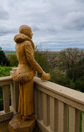 Prestatyn, UK; April 2018; Chainsaw sculpture of a woman dressed in 1930's style looks out across Prestatyn towards the sea from the Hillside Gardens Shelter.のeditorial素材