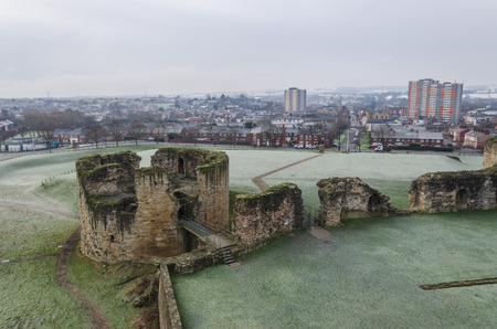Flint, UK. 31 January 2019. A sharp hoar frost coats the grassy area around Flint Castle. The town of Flint lies in the background.のeditorial素材