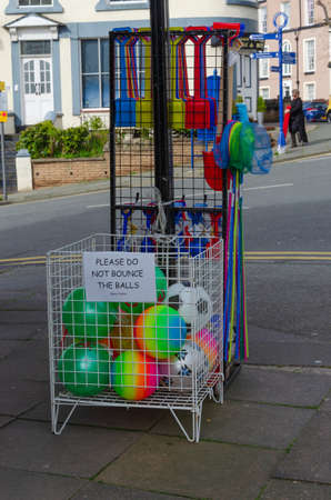 Llandudno, UK : May 6, 2019: A general street scene at Llandudno on a sunny morning with plastic seaside toys for sale displayed on the pavement.のeditorial素材