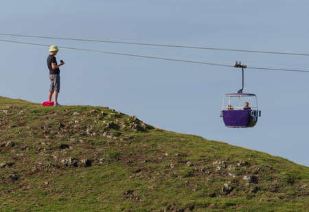 Llandudno, UK: Aug 27, 2019: A photographer stands on the Great Orme to take a photograph of the cable cars.のeditorial素材