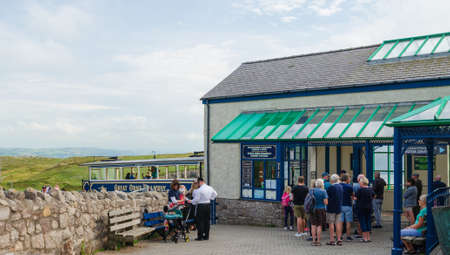 Llandudno, UK: Aug 27, 2019: A queue of visitors at the summit tramway station of the Great Orme, waiting to take a ride on the Victorian cable hauled tram.のeditorial素材