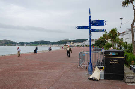 Llandudno, UK: Aug 27, 2019: A rolled up carpet is dumped beside a litter bin on the promenade of the seaside resort of Llandudno.のeditorial素材